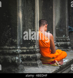 Le moine bouddhiste médite en colonnade, complexe du temple d'Angkor Wat, parc archéologique d'angkor, province de Siem Reap, Cambodge Banque D'Images