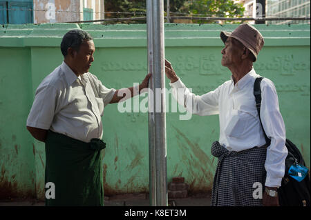 27.01.2017, Yangon, Yangon, région de la république de l'Union du Myanmar, en Asie - deux hommes sont vu debout à un arrêt de bus dans le centre de Yangon. Banque D'Images