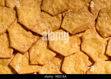 Crispy bio grain entier, craquelins cuits multigrains comme arrière-plan. mélange de grains entiers : avoine, farine de riz, millet, quinoa, amarante, sésame voir Banque D'Images