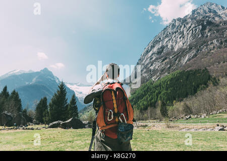 Vue arrière de l'homme boulderer photographier les montagnes, Lombardie, Italie Banque D'Images