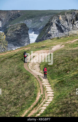 Bedruthan Steps - Walkers grimper des marches sur le South West Coast Path au Bedruthan Steps sur la côte nord des Cornouailles. Banque D'Images