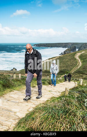 Bedruthan Steps - walkers grimper le sentier raide au Bedruthan Steps sur la côte nord des Cornouailles. Banque D'Images