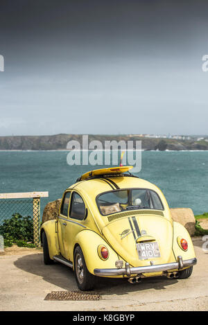 - Une voiture Volkswagen Volkswagen jaune avec un surf sur son toit stationné à peu dans Fistral Newquay, Cornwall Banque D'Images