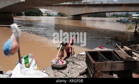 Jeunes filles laver des vêtements sous le pont Monivong Phnom Penh Cambodge la vie le long de la région du fleuve Bassac Vietnam Cambodge Banque D'Images