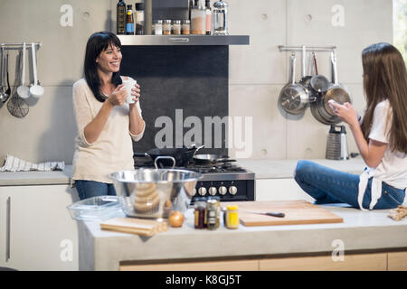 Mère et fille avoir conversation en cuisine Banque D'Images