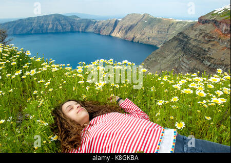 Jeune fille endormie sur un lit de fleurs, Oia, Santorin, Grèce, Kikladhes Banque D'Images