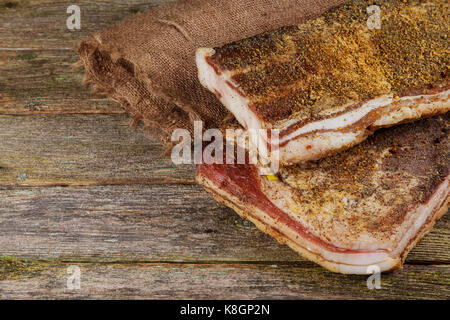 Avec bacon salé sur une table en bois, graisse de porc salé avec des épices. Bacon, l'oignon, l'ail, épices sur une planche de bois. Banque D'Images