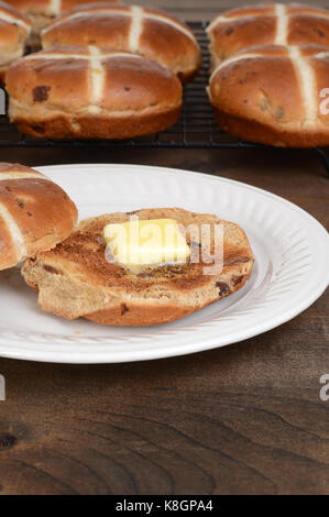 Hot cross bun grillé avec du beurre Banque D'Images