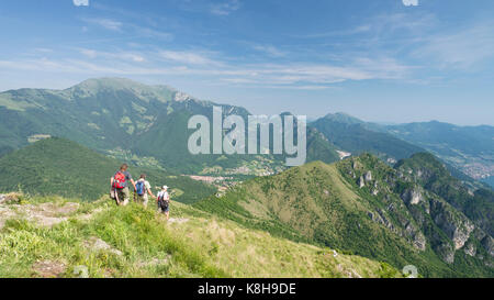 Descente d'un groupe de randonnée de la montagne de trentapassi sur le lac d'Iseo avec une vue panoramique sur Monte vignole, monte guglielmo et Punta almana, italie Banque D'Images