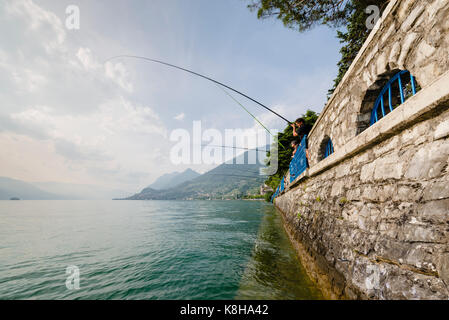 Angler mit langen angelruten an der mauer der seepromenade vente von marasinao am iseosee sale marasino, Lombardie, Italie Banque D'Images