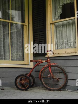 Vieux tricycle sur un porche Banque D'Images