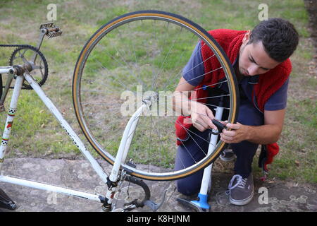 Jeune homme gonflant un pneu de vélo. france. Banque D'Images