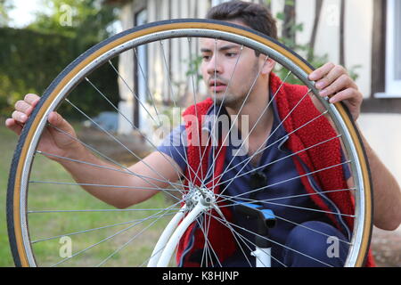 Jeune homme gonflant un pneu de vélo. france. Banque D'Images