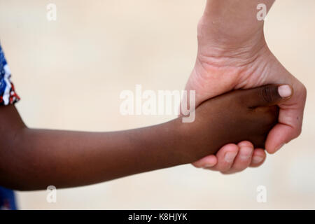 Travailleur humanitaire tenant la main de l'enfant. lome. le Togo. Banque D'Images