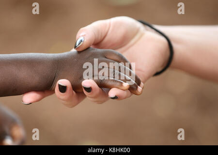 Travailleur humanitaire tenant la main de l'enfant. le Togo. Banque D'Images