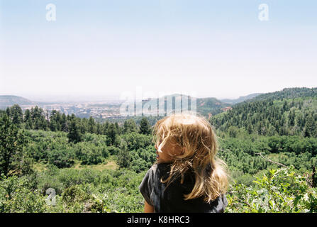 Carefree girl looking at view contre ciel clair Banque D'Images