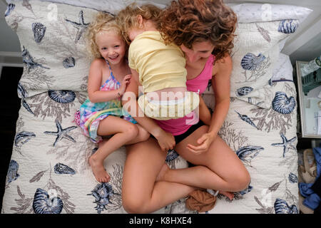 Portrait de mère en filles assis sur le lit à la maison Banque D'Images