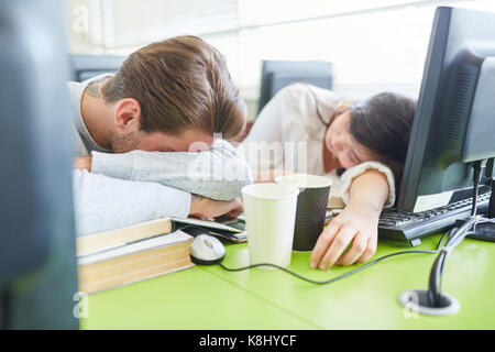 Les étudiants avec la fatigue en sommeil avant de l'ordinateur en classe universitaire Banque D'Images