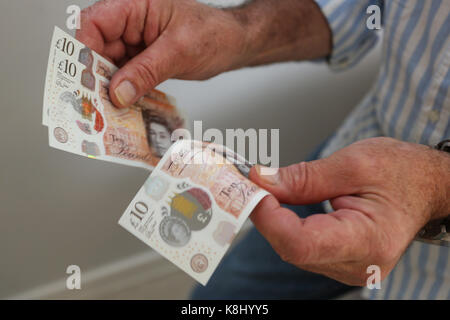 Un homme photographié tenant une nouvelle note de dix livres à son domicile de Chichester, West Sussex, UK. Banque D'Images