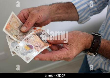 Un homme photographié tenant une nouvelle note de dix livres à son domicile de Chichester, West Sussex, UK. Banque D'Images