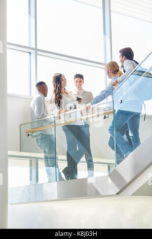 Les élèves des petites parler pendant les pauses dans les escaliers de l'université Banque D'Images