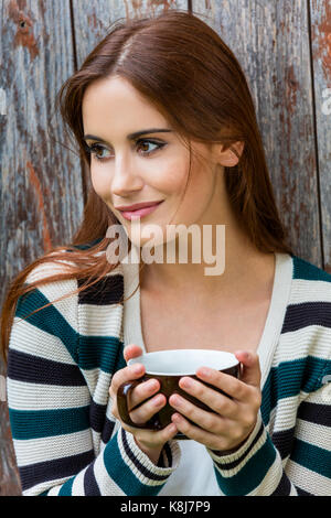 Portrait d'une belle jeune fille ou jeune femme aux cheveux rouges de boire du thé ou du café Banque D'Images