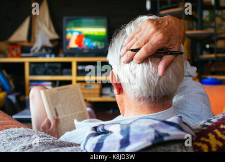 Vieil homme regarder la télévision Banque D'Images