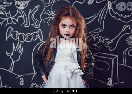 Fille dans bride of chucky doll costume sur fond sombre avec des illustrations d'halloween. Banque D'Images