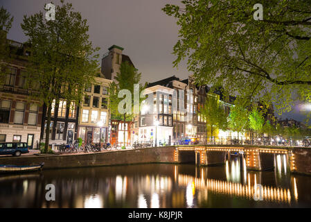 Vue de nuit Amterdam cityscape avec canal, pont et maisons de la cité médiévale dans le crépuscule du soir allumé. Amsterdam, Pays-Bas Banque D'Images