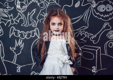 Fille dans bride of chucky doll costume sur fond sombre avec des illustrations d'halloween. Banque D'Images