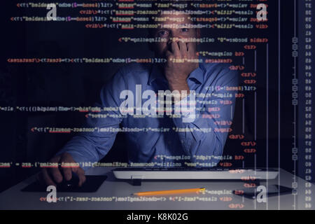 Programmeur travaillant avec les codes de programmation sur l'écran de l'ordinateur dans une pièce sombre Banque D'Images