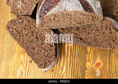 Morceaux de pain de seigle sur une vieille table en bois. photo close up Banque D'Images