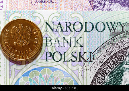 Une pièce de monnaie polonaise, couché sur le papier monnaie de Pologne. photographiés de près. Banque D'Images