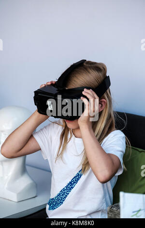 Jeune fille portant le casque Oculus Gear VR, équipement de réalité virtuelle métaverse (VR) avec téléphone Samsung. Banque D'Images