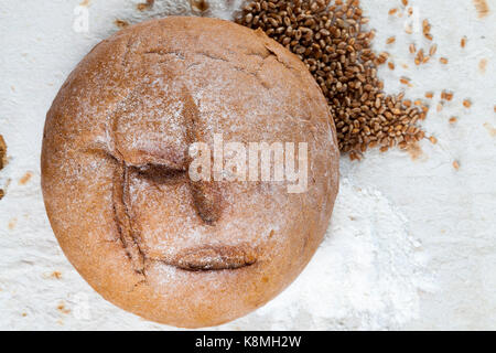Une miche de pain de seigle, couché sur un pain pita de blé minces. avec du pain se trouve des céréales et de la farine. photo gros plan, Vue de dessus Banque D'Images