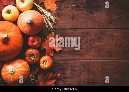 Contexte : thanksgiving citrouilles, pommes, blé, feuilles d'érable, les cônes et les épices sur fond de bois brun automne saison. arrière-plan pour Thanksgiving Banque D'Images