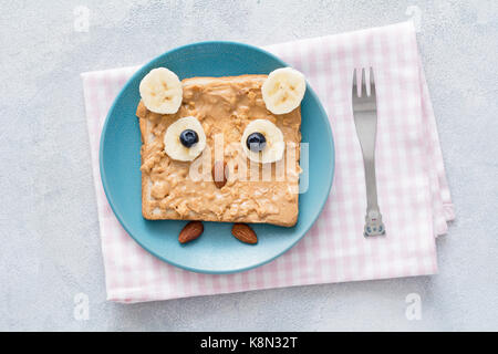 Toast au beurre d'arachide pour les enfants petit déjeuner sain dans la forme de cute owl sur une plaque bleue Vue de dessus de table. Banque D'Images