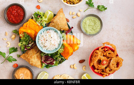 Thali indien végétarien épicé avec riz jeera, diverses salades et sauces sur surface rustique. Vue de dessus, l'espace vide Banque D'Images