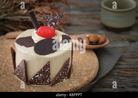 Gâteau à la vanille avec cerises sur fond de bois en faible lumière, la sélection du point af, copie de l'espace pour écrire. Banque D'Images