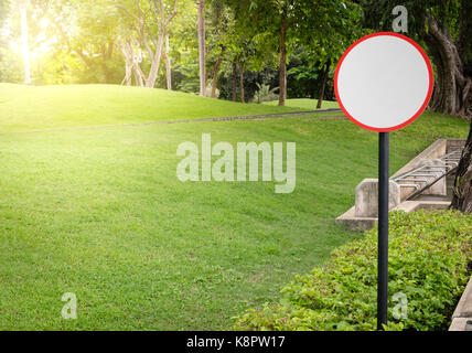 Cercle blanc vide panneau dans le vert du parc dans la soirée il y a de la lumière orange avec copie espace pour écrire. Banque D'Images