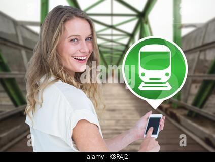 Digital composite of Woman holding phone avec l'icône sur la voie de chemin de fer Banque D'Images