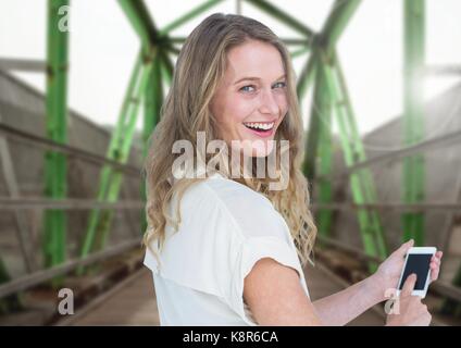 Digital composite of Woman holding phone avec voie de chemin de fer Banque D'Images