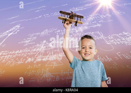 Portrait of boy holding toy airplane contre sunrise sky Banque D'Images