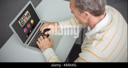 Machine à sous avec du texte et des chiffres sur l'écran mobile contre l'enseignant attentif using laptop in library Banque D'Images