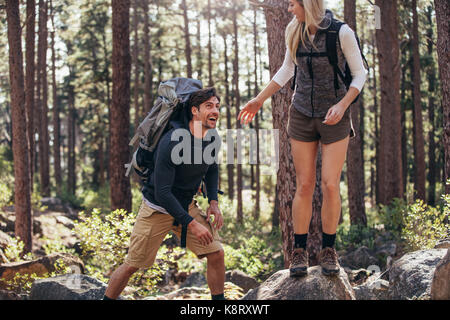 L'homme et la femme les randonneurs appréciant la randonnée sur sentier rocheux. Explorer la nature couple randonneur marchant à travers les bois. Banque D'Images