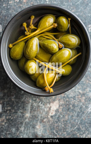 Caper marinés dans un bol de fruits sur la table de cuisine. Banque D'Images