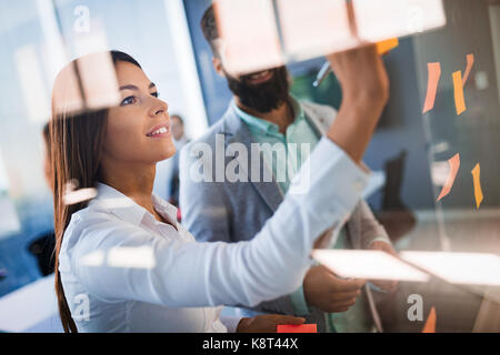 Photo de designers coller notes in office Banque D'Images