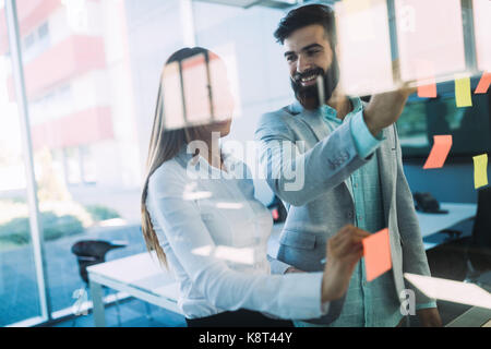 Photo de designers coller notes in office Banque D'Images