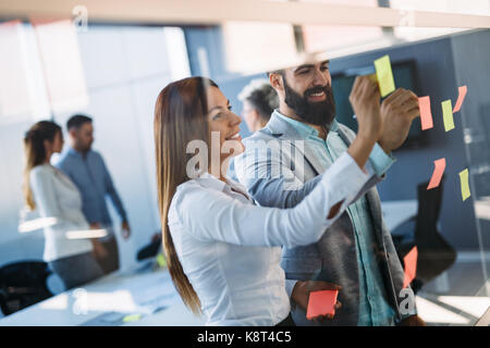 Photo de designers coller notes in office Banque D'Images