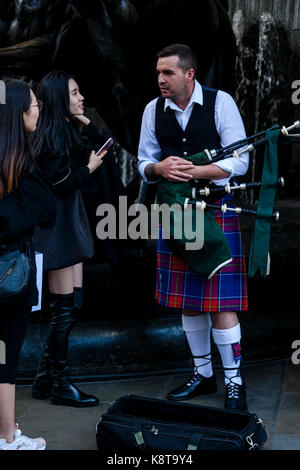 Les femmes qui discutent avec un artiste de rue, Piccadilly Circus, Londres, UK Banque D'Images